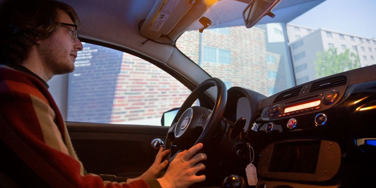 Doctoral student David Goedicke sits behind the wheel of the Fiat virtual simulation vehicle, inside the Tata Center at Cornell Tech. Lindsay France/Cornell University