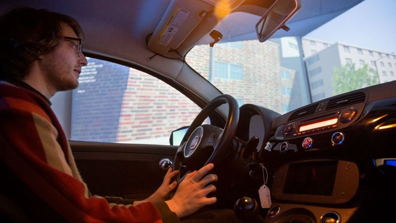 Doctoral student David Goedicke sits behind the wheel of the Fiat virtual simulation vehicle, inside the Tata Center at Cornell Tech. Lindsay France/Cornell University