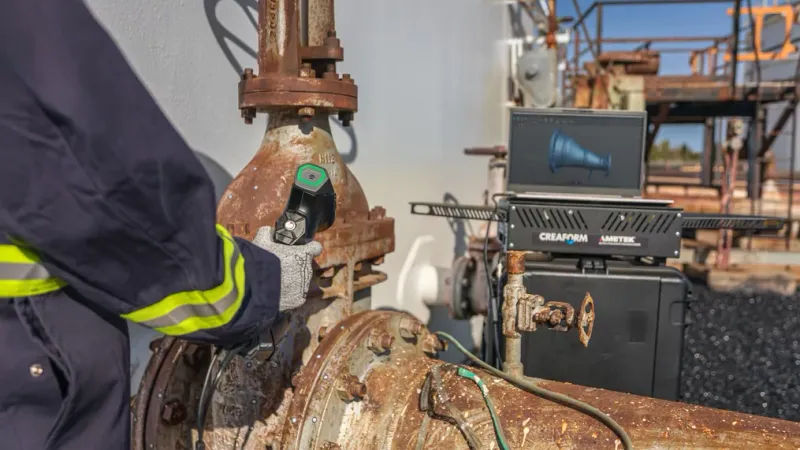 NDT technician holding a metrology-grade 3D scanner and inspecting the corrosion on a corroded valve.
