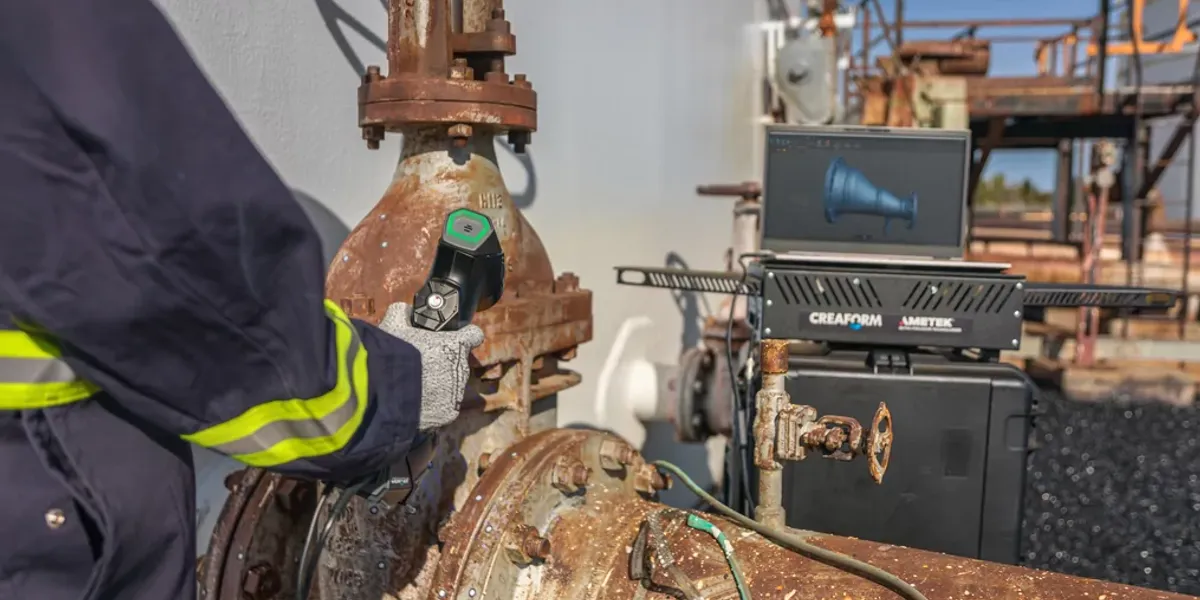 NDT technician holding a metrology-grade 3D scanner and inspecting the corrosion on a corroded valve.
