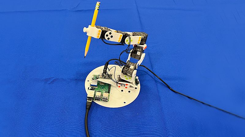 A 3D-printed robotic arm holds a pencil as it trains using random movements and a single camera — part of a new control system called Neural Jacobian Fields (NJF). Rather than relying on sensors or hand-coded models, NJF allows robots to learn how their bodies move in response to motor commands purely from visual observation, offering a pathway to more flexible, affordable, and self-aware robots. Image courtesy of the researchers.