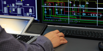 An engineer using SCADA to monitor and control industrial processes via PLC.