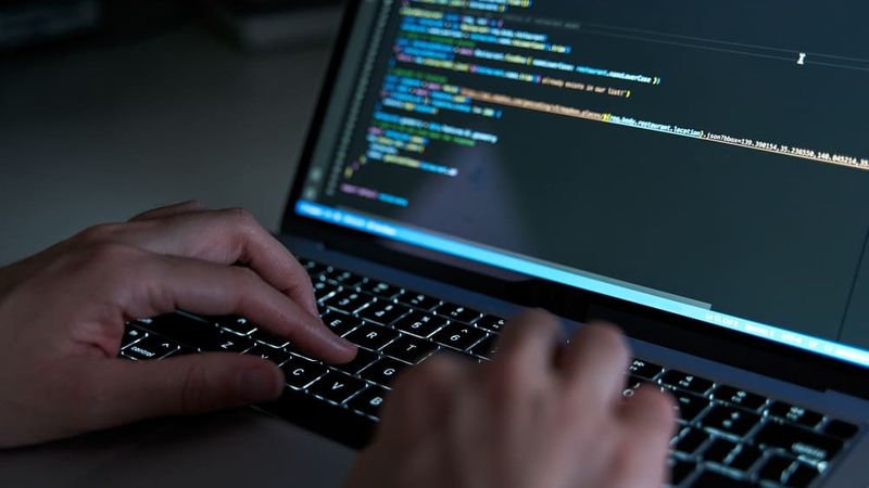 An engineer checking security systems on laptop