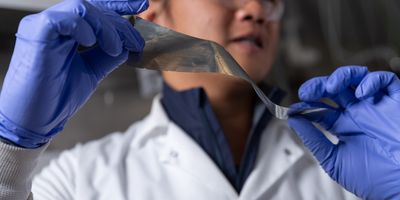 Graduate student researcher Yuhgene Liu holds an aluminum material for solid-state batteries.