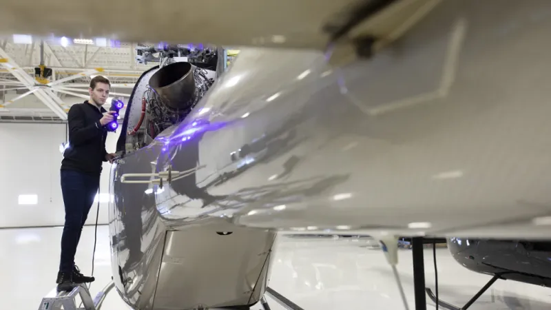 Engineer scanning a helicopter engine with a metrology-grade 3D scanner.