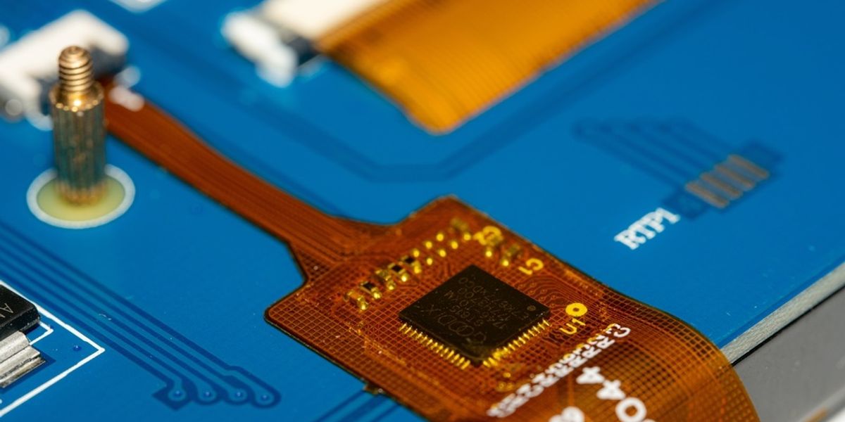 Close-up of a Rigid-Flex PCB featuring a microchip and miniature electronic components