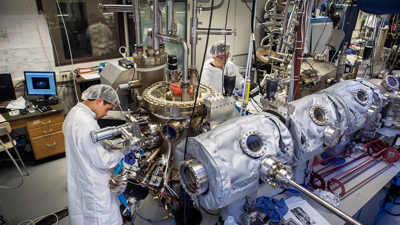 Jordan Occena, a U-M graduate researcher and Sunyeol Jeon, a former U-M graduate student researcher, calibrate the molecular-beam epitaxy apparatus in the Carl A. Gerstacker Building on August 3, 2015. The apparatus is used for spray painting the "magic" chemical cocktail onto blank gallium arsenide wafers. PHOTO: Joseph Xu, Michigan Engineering