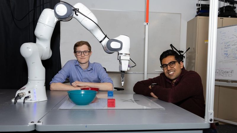 PhD students Aidan Curtis (left) and Nishanth Kumar. To help robots execute open-ended tasks safely, the researchers used vision models to see what’s near the machine and model its constraints. Their “PRoC3S” strategy has an LLM sketch up an action plan that’s checked in a simulator to ensure it will work in the real world. Credits: Mike Grimmett/MIT CSAIL