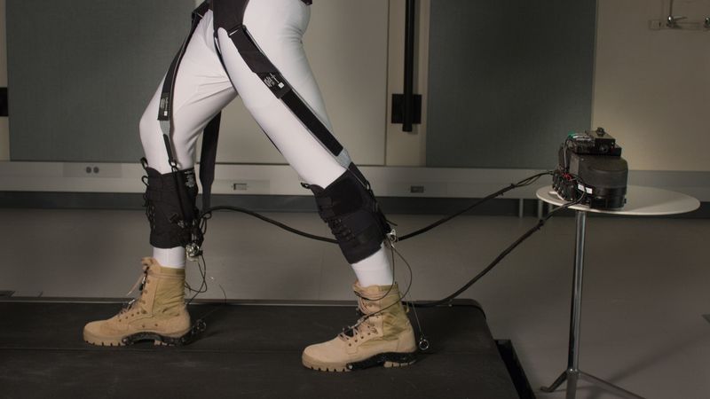 The exosuit’s soft textiles strategically position the actuating cables that assist with the ankle motion at the back of the lower legs, and, through additional straps, transfers energy produced at the ankle to the front of the hip to also assist with the gait’s hip motion. 