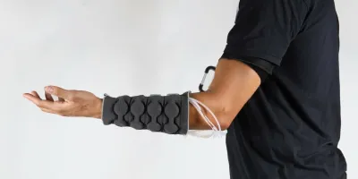 Haptiknit sleeve worn on the arm, including the control system on the upper arm. | Susan Williams, MIT Self-Assembly Lab