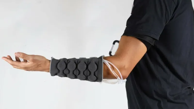 Haptiknit sleeve worn on the arm, including the control system on the upper arm. | Susan Williams, MIT Self-Assembly Lab