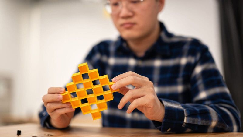 Xiangxin Dang, a postdoctoral researcher, displays an adjustable structure made from a cardboard sheet. Photos by Sameer A. Khan/Fotobuddy