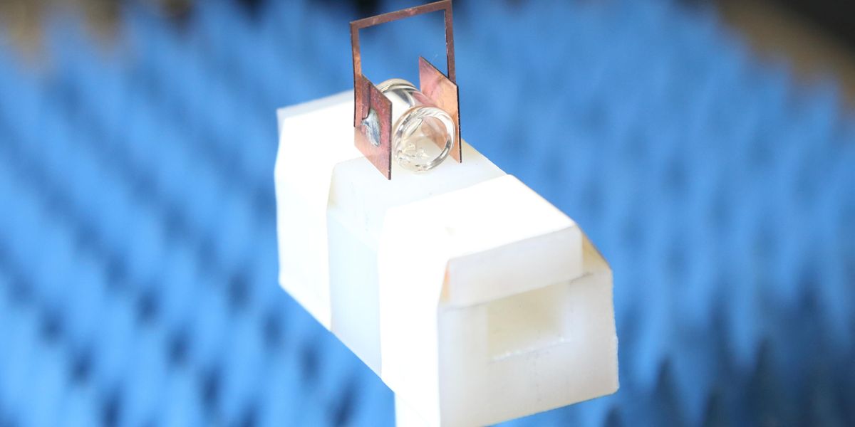 Copper “headphones” boost the sensitivity of NIST’s atomic radio receiver, which is composed of a gas of cesium atoms prepared in a special state inside the glass container. When an antenna located above the setup sends down a radio signal, the headphones boost the strength of the received signal a hundredfold.  Credit: NIST