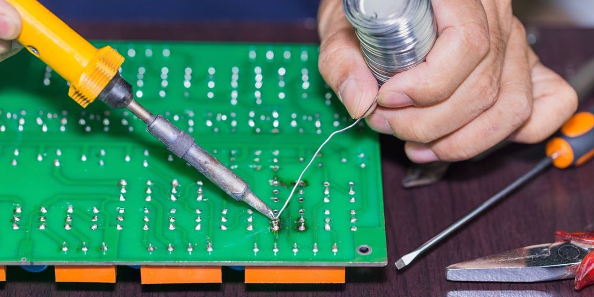 Soldering on circuit board with soldering iron and solder in board repairing