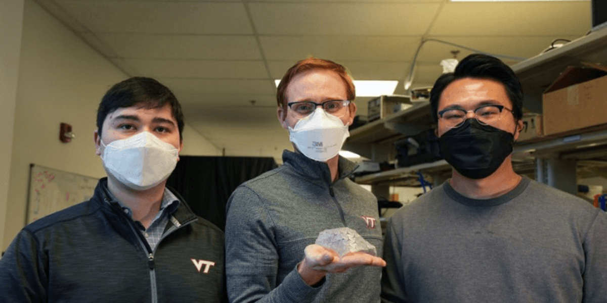 The researchers holding a piece of material that has been warped [Image Source: Virgnia Tech Blog]