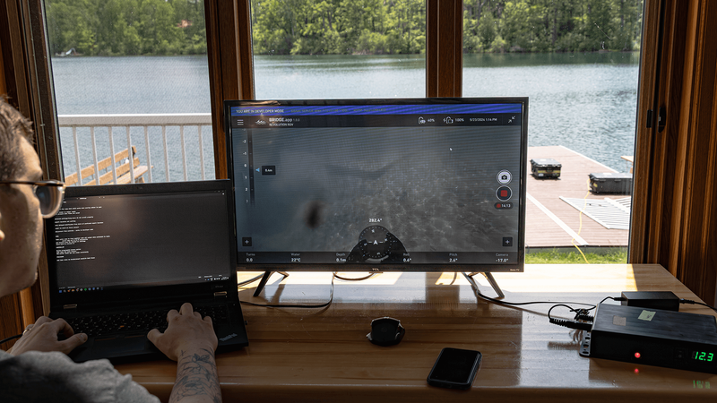 Operator using custom keyboard controls and laptop to pilot ROV.