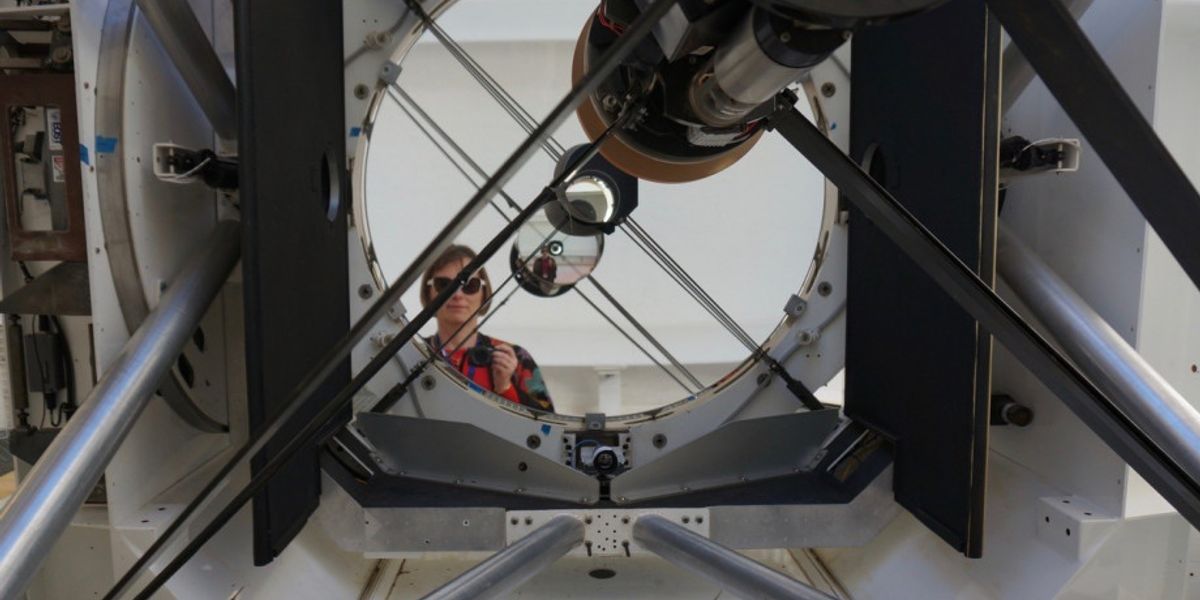 In this picture ANU instrument scientist Celine d'Orgeville stands in front of the EOS 1.8 meter telescope at Mount Stronio Observatory where her image is reflected an infinite amount of times by the two telescope mirrors,