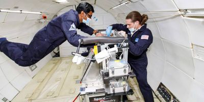 Space Foundry CEO and co-founder Dr. Ram Prasad Gandhiraman (left) and CTO and co-founder Dr. Dennis Nordlund operate the company’s plasma jet printing of electronics experiment in microgravity on a parabolic flight in December 2021 Credits: Zero Gravity Corporation/Steve Boxall