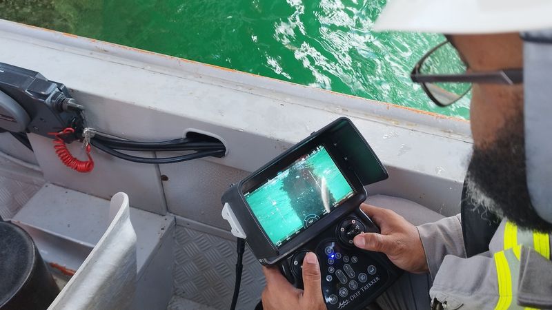 operator piloting underwater ROV on Deep Trekker handheld controller