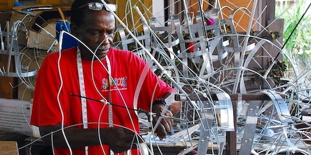 An artisan from Trinidad and Tobago uses traditional skills to build an intricate wire frame that will support a large, elaborate Carnival costume. 