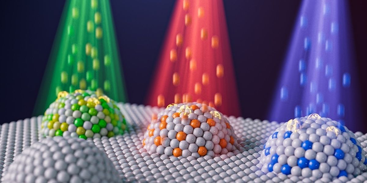 Artist’s representation of nanoparticles with different compositions created by combining two techniques: metal exsolution and ion irradiation. The different colors represent different elements, such as nickel, that can be implanted into an exsolved metal particle to tailor the particle’s compositions and reactivity. Image: Jiayue Wang