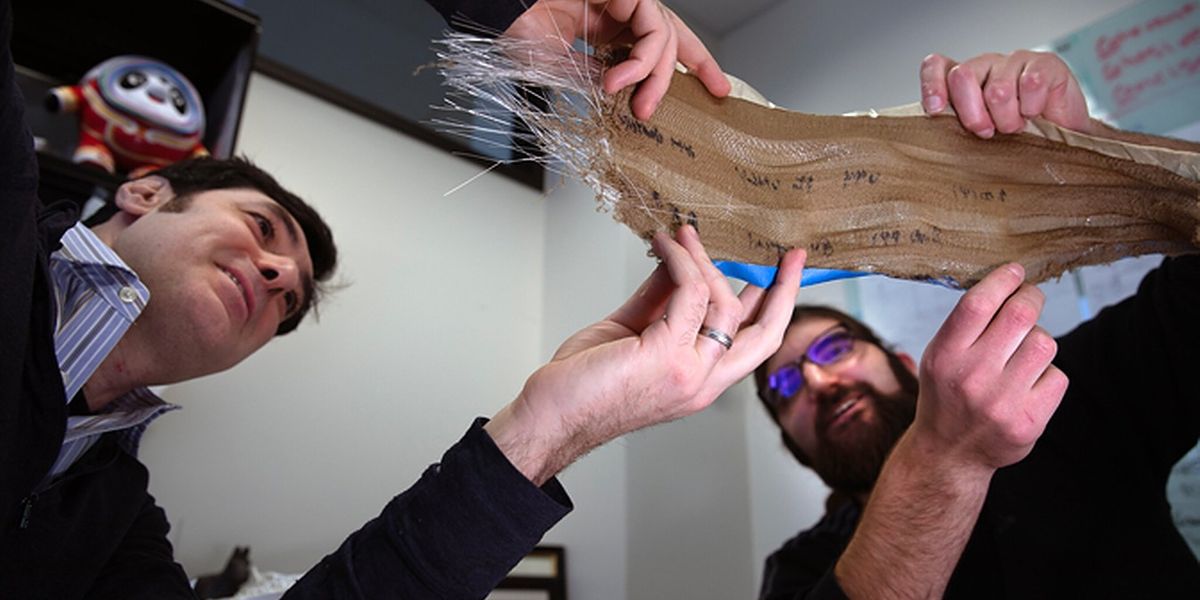 Max Stein and Brian Iezzi analyze the fabric with photonic fibers woven into it. Photo: Marcin Szczepanski/Michigan Engineering