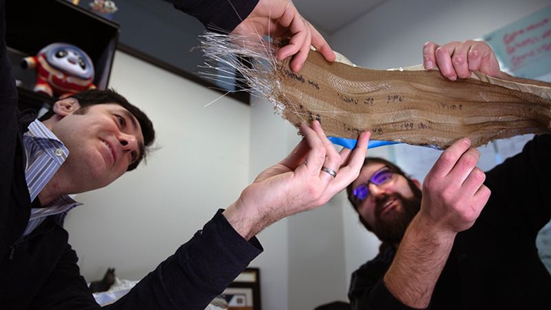 Max Stein and Brian Iezzi analyze the fabric with photonic fibers woven into it. Photo: Marcin Szczepanski/Michigan Engineering