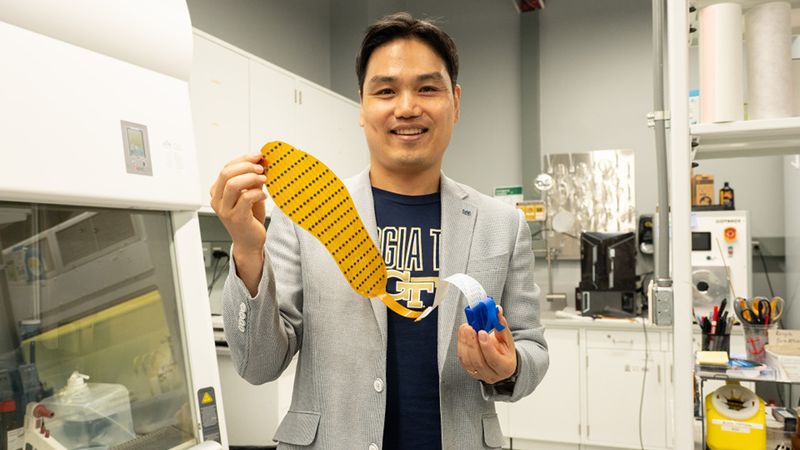 Hong Yeo holds the wearable electronic device made of more than 170 thin, flexible sensors that measure foot pressure — a key metric for determining whether someone is off-balance. [Photos by Joya Chapman]