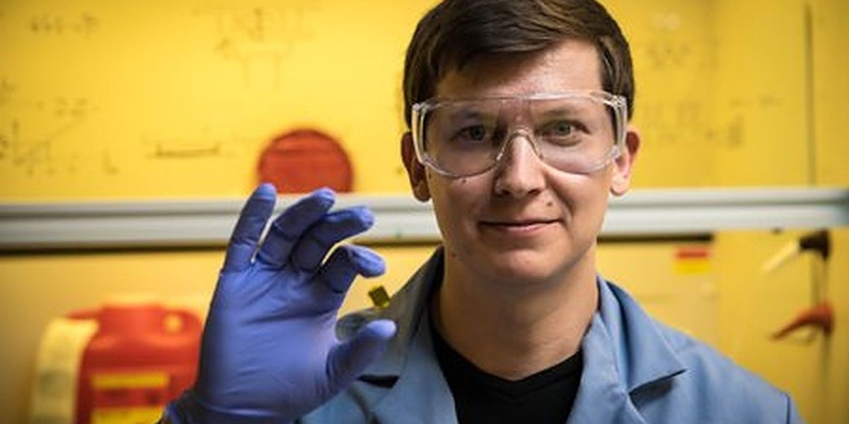 Caltech graduate student Andrey Vyatskikh shows a square of silicon substrate upon which a 3-D metal structure has been printed. The structure itself is smaller than a speck of dust.