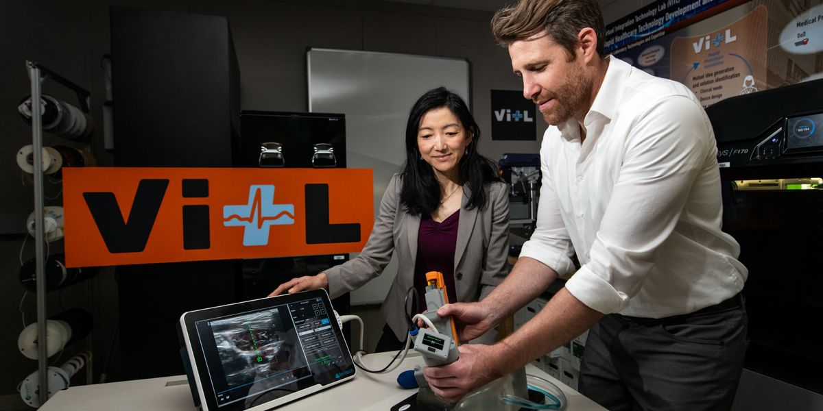 Matt Johnson (right) and Laura Brattain test a new medical device on an artificial model of human tissue and blood vessels. The device helps users to insert a needle and guidewire quickly and accurately into a vessel, a crucial first step to halting rapid blood loss. Photo: Nicole Fandel