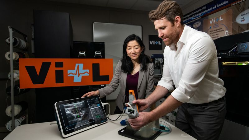 Matt Johnson (right) and Laura Brattain test a new medical device on an artificial model of human tissue and blood vessels. The device helps users to insert a needle and guidewire quickly and accurately into a vessel, a crucial first step to halting rapid blood loss. Photo: Nicole Fandel