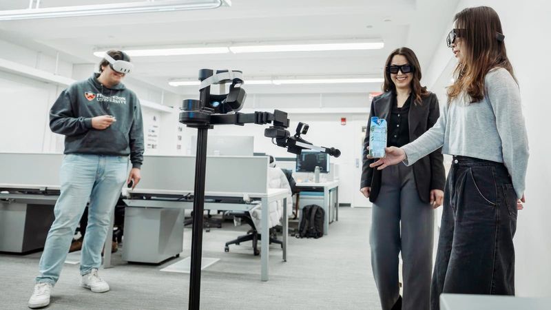 Computer scientists Parastoo Abtahi, center, and Mohamed Kari, left, are are working to bring virtual reality into the physical world by pairing mixed reality headsets with robots. Doctoral student Lauren Wang, right, assists in demonstrating how the robot operates. Image by Nick Donnoli/Orangebox Pictures