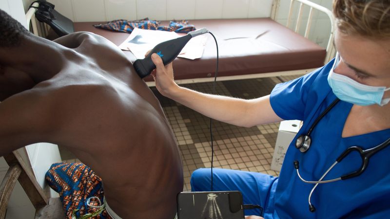 Dr. Véronique Suttels performs a smartphone-connected ultrasound on a symptomatic Beninese patient - 2025 EPFL/Véronique Suttels - CC-BY-SA 4.0