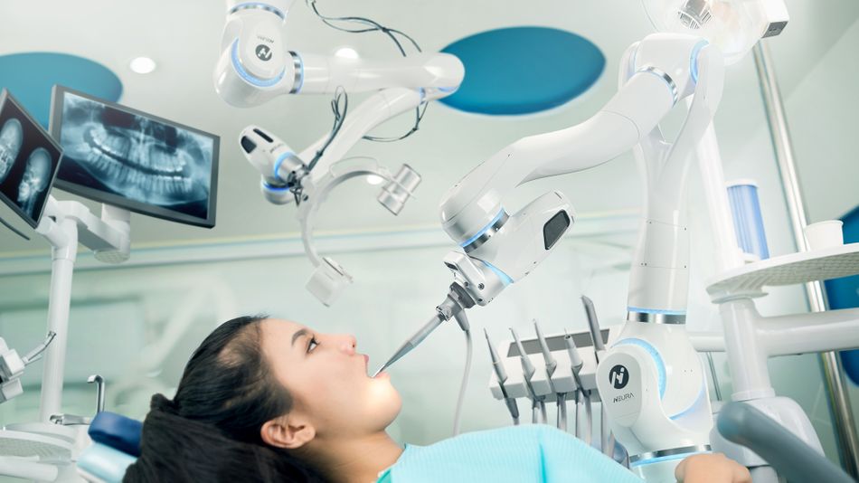 A robot places a dentistry tool inside a patients mouth. 