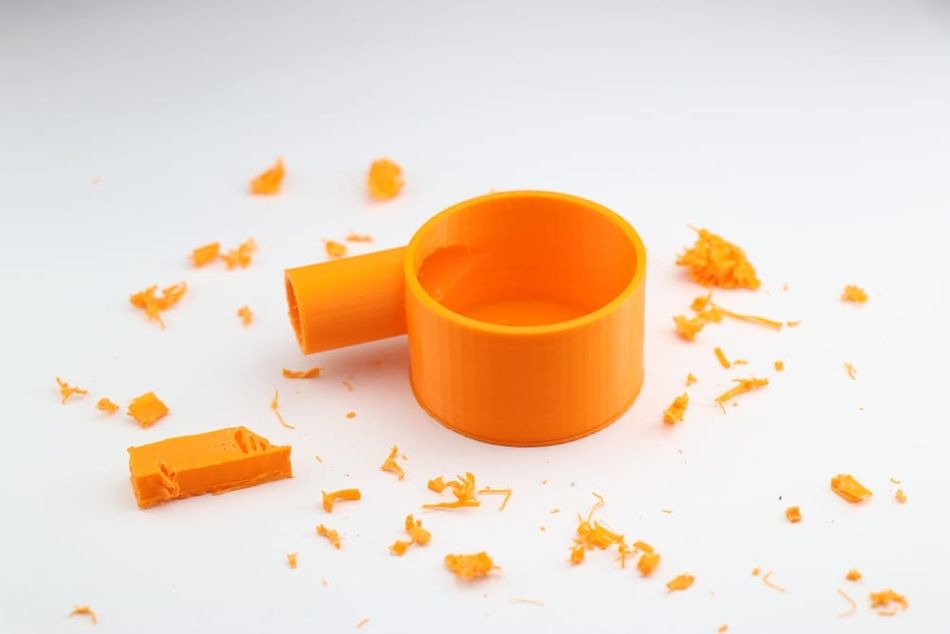 Orange 3D printed part with supports removed