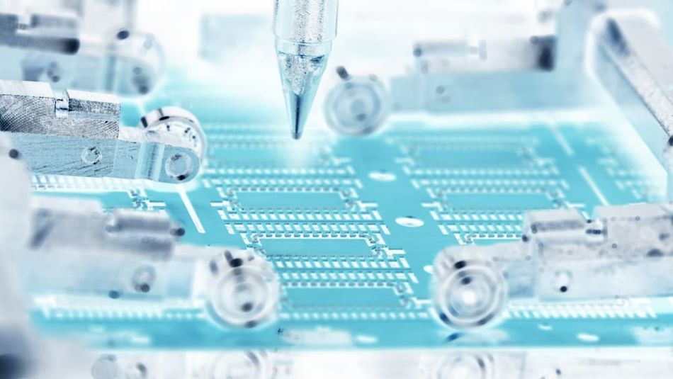 The die attach machine in this image is used to make semiconductors, and you can see negative color epoxy writing on the lead frame.