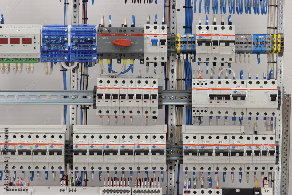 Contactors and relays on a metal rail in the electrical panel