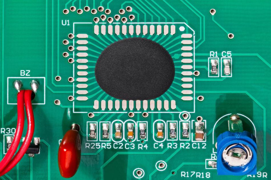 IC covered by a black epoxy blob and embedded in green PCB 