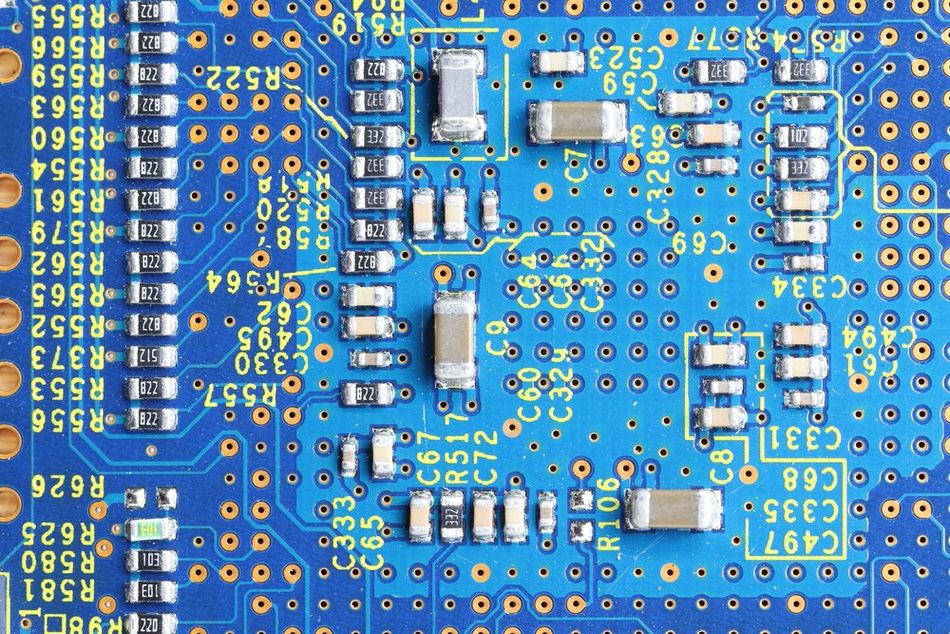 An image of a blue PCB, showing SMD resistors of various values