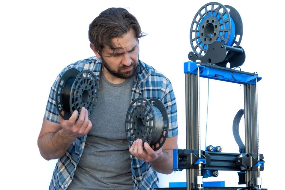 Man selecting two spools of filament