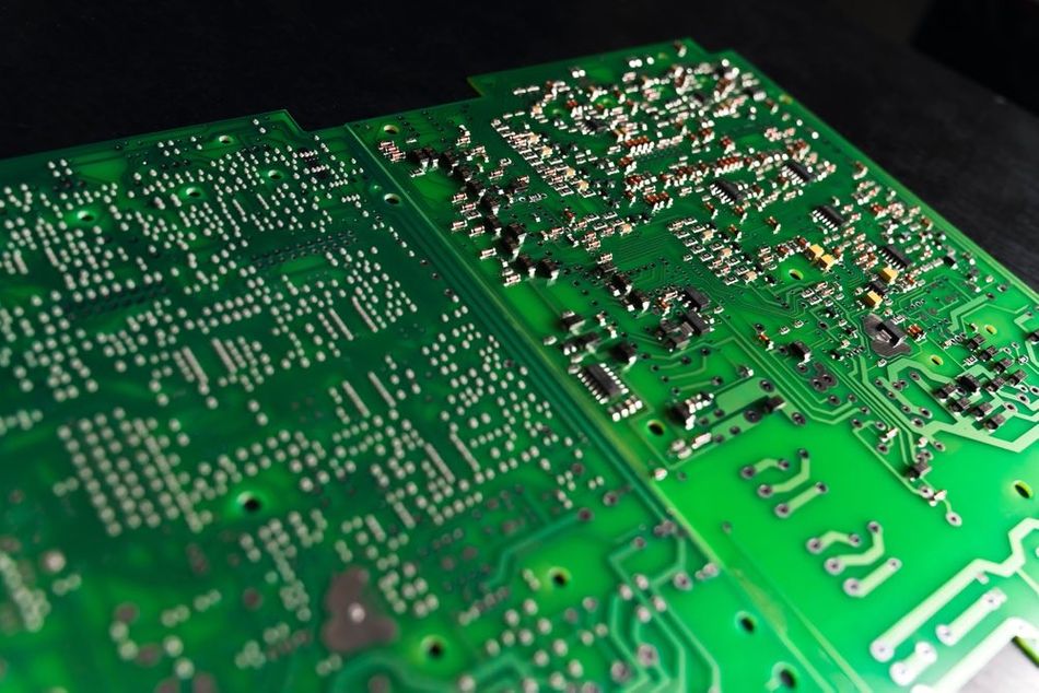 A high-quality image of a multi-layered SMD green printed electronic circuit board adorned with components.
