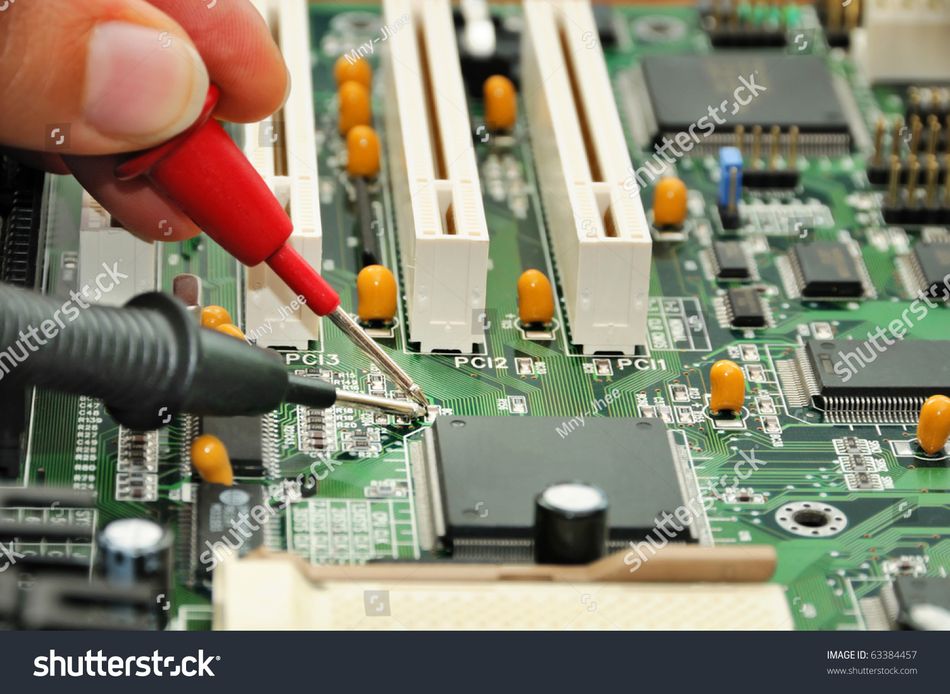 In the service center, a technician carefully examines and tests an printed circuit board.