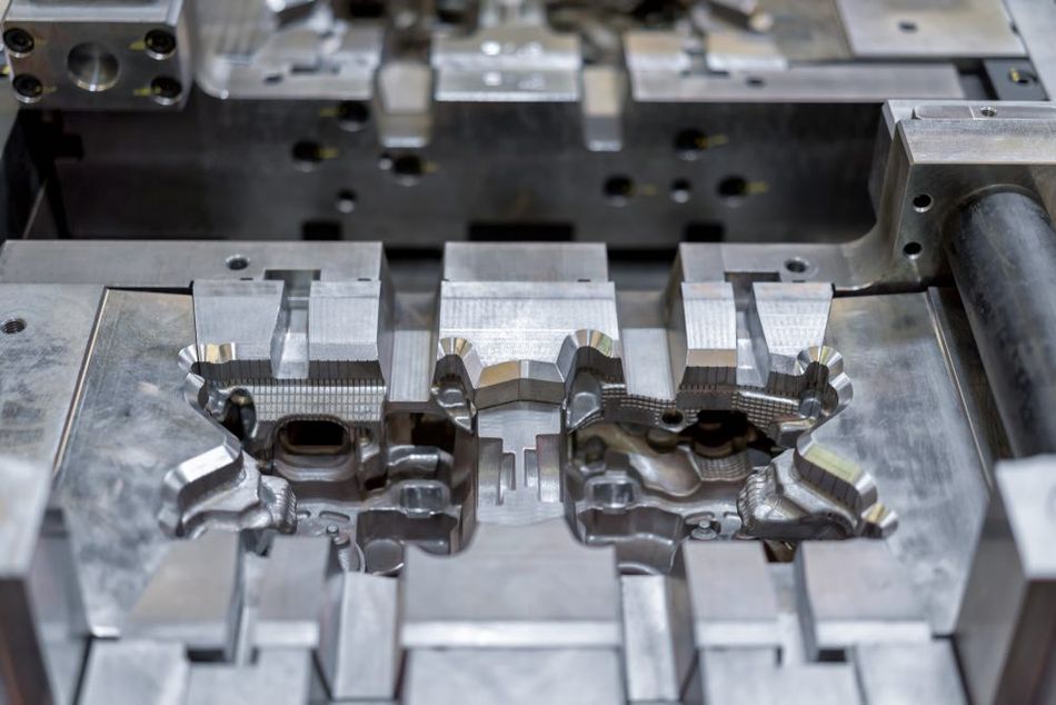 Close-up view of industrial metal die in a factory setting.