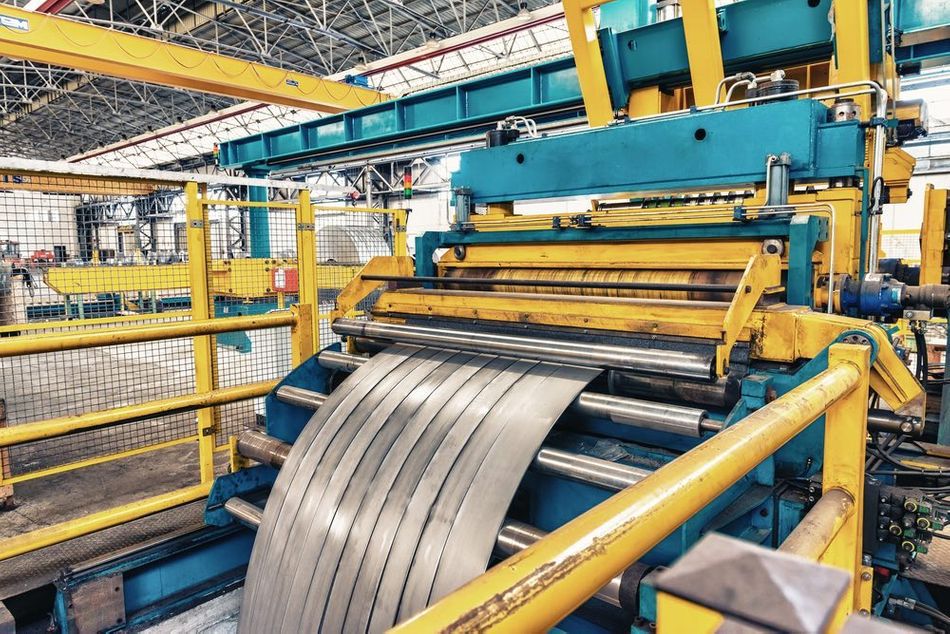A large machine in the process of rolling the steel.