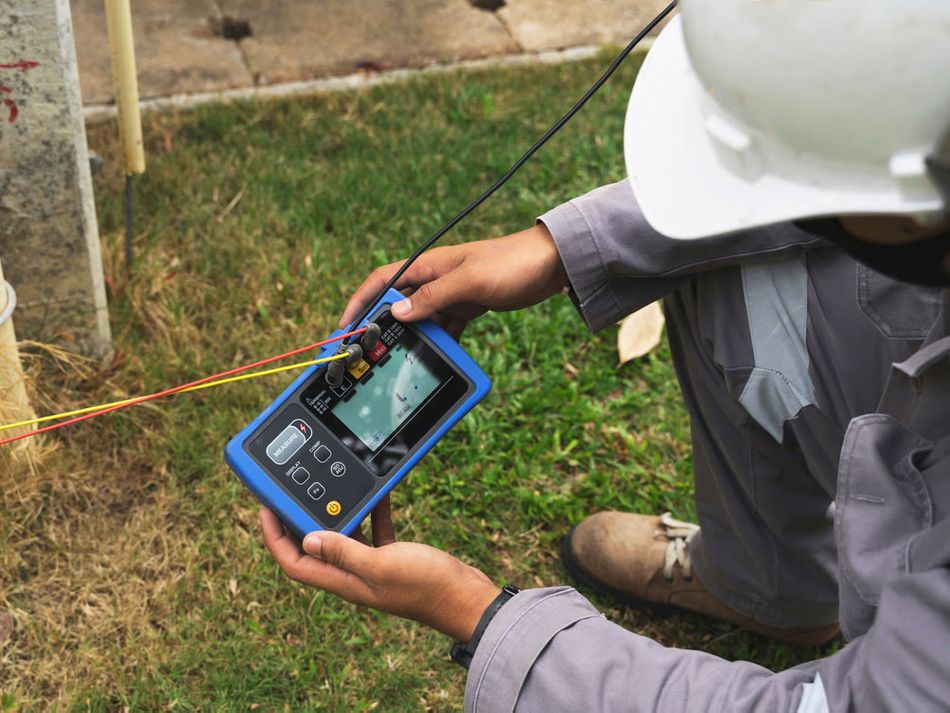 An engineer uses a smart testing device for ground testing
