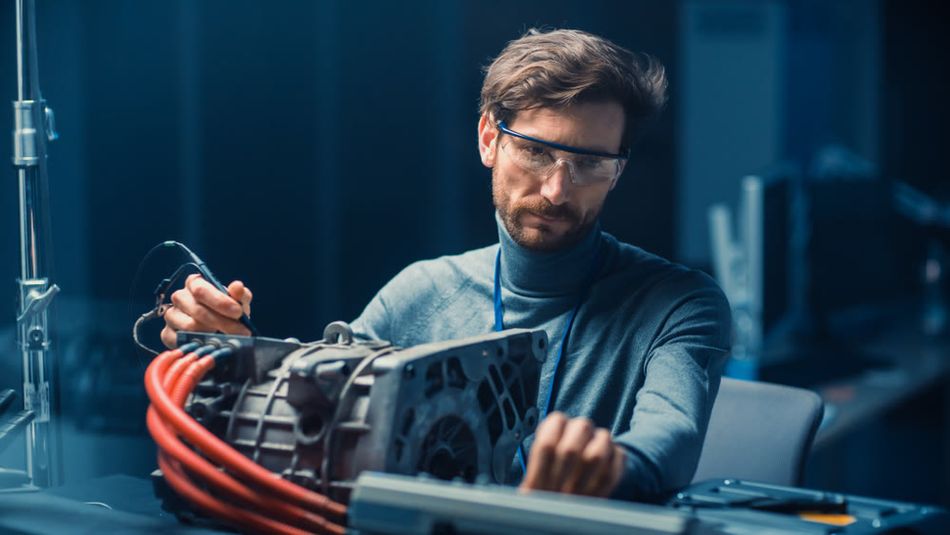 An automotive engineer testing an electrical engine.