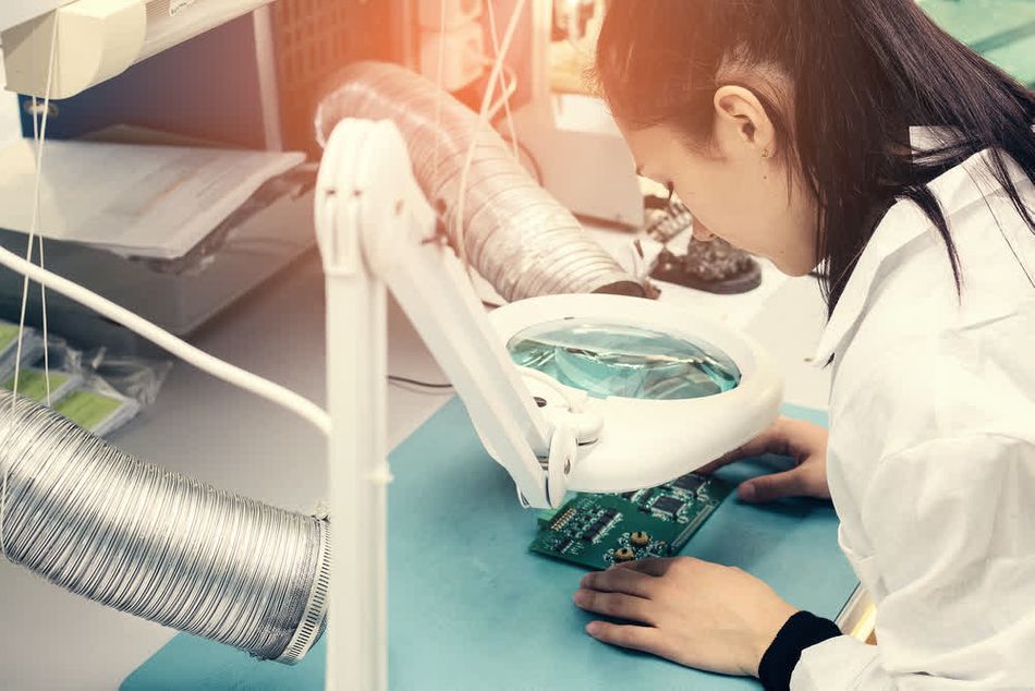 An expert inspecting PCB coating