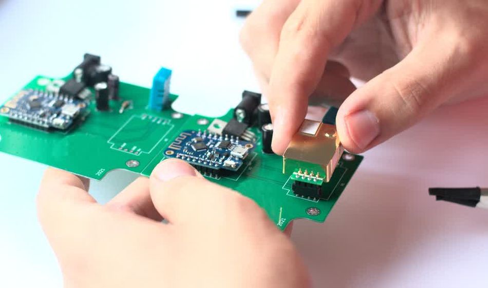 A designer completing a PCBA by placing components on a PCB