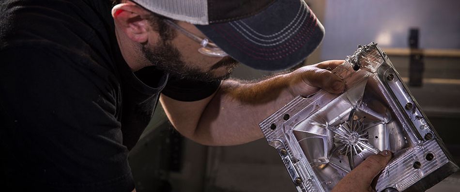 Worker inspecting moulded part.