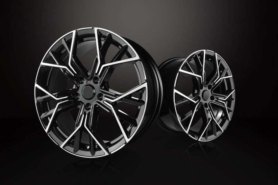 Two shiny black aluminum car rims with a modern design on a dark background.